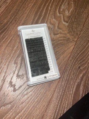 Svarta volymfransar Luxurious Lashes - Säljer två askar LL VolumeLashes från Luxurious Lashes i svart. Ena asken innehåller fransar i D-böj, 0.07 tjocklek och 9 mm längd, den andra i D-böj, 0.07 tjocklek och 8 mm längd. Perfekta för volymfransförlängning. Fransarna är av syntetmaterial och kommer i praktiska plastaskar. Nytt skick har endast använt en rad av fransarna i 8mm