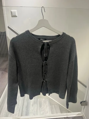 Grå stickad cardigan från Ginatricot, XS - Trendig mörkgrå stickad cardigan från Ginatricot med tre knytband framtill. Pris kan diskuteras💖