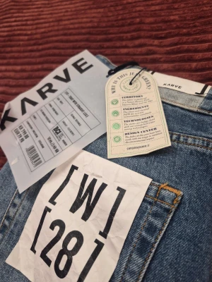 Blå raka jeans från Karve tight fit straight leg W28 - Snygga blå jeans från Karve i rak modell med klassisk femficksdesign och ljus tvätt. Jeansen har vita sömmar och är tillverkade i ekologisk bomull. Perfekta för en avslappnad och trendig look.