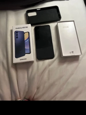 Samsung Galaxy A15 5G – som ny, redo att användas!	•	Prisvärd Samsung A15 5G inkl. skal & originalkartong	•	Perfekt skick! Galaxy A15 5G med tillbehör - Säljer min Samsung Galaxy A15 5G 128gb  i mycket fint skick. Funkar perfekt utan några problem.  Mobilen är sparsamt använd och har inga sprickor i skärmen. Mindre bruksspår kan finnas men inget som påverkar användningen.
