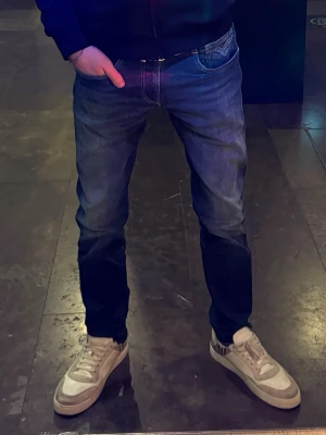 Blå Replay Hyperflex jeans - Helt nya snygga blå jeans från Replay, modell Hyperflex Anbass. Slim fit passform med snygg röd Replay logga på bakfickan. Dessa jeans ör aldrig använda, första bilden är samma jeans då jag har två lika dana men dessa är helt oanvända. Storlek: w31 L34. Skriv görna vid frågor.