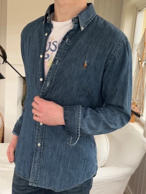 Skitsnygg Ralph Lauren denim skjorta - modell: 182cm, 72kg. sitter helt perfekt, skit snygg perfekt till sommaren!!!! hatar att jag behöver sälja den här 😫Medium slim fit