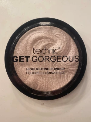 Technic Highlighter - Technic Get Gorgeous Highlighting Powder i en skimrande champagnefärg. Pudret har en swirl-design och kommer i en rund svart plastförpackning med genomskinligt lock. Perfekt för att ge glow till ansiktet.