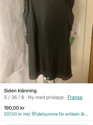 Mörkgrön sidenklänning från Fransa - En enkel och stilren mörkgrön klänning från Fransa i sidenmaterial. Klänningen är ärmlös och har en rak, kort modell som passar perfekt för dig som gillar minimalistisk design. Siden ger en lyxig känsla och fin lyster.