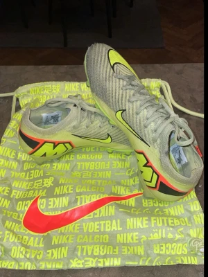 Ordinarie pris 3100 Nike Mercurial fotbollsskor gul - Säljer ett par Nike Mercurial fotbollsskor i neongula och svarta detaljer samt orange logga. Skorna har en smal, strömlinjeformad design och ovandel i syntetmaterial för bra bollkontroll. Perfekta för dig som vill ha en skön och bra sko.