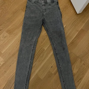 Gråa skinny jeans med hög midja - Säljer ett par gråa skinny jeans med hög midja och klassisk femficksdesign. Jeansen har en tvättad look och smala ben som sitter tight hela vägen ner. Perfekta för en trendig och avslappnad stil. Stl:158