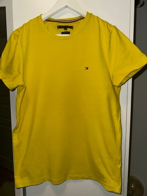 Gul t-shirt Tommy Hilfiger - Snygg ljus gul t-shirt från Tommy Hilfiger i extra slim fit. Klassisk rund halsringning och liten broderad logga på bröstet. Tillverkad i mjuk bomull som känns skön mot huden. Perfekt för dig som gillar färg och stilren design.