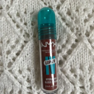 NYX Lip IV Hydrating Gloss Serum Hydra Honey - NYX Lip IV Hydrating Gloss Serum är ett gloss i en brunrosa nyans. Ger återfuktande känsla och glans till läpparna. Perfekt för dig som vill ha ett glossigt resultat med extra vård. Färg Hydra Honey.