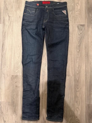 Replay Anbass Mörkblå Jeans W30/L34 Slim Fit - Replay Anbass mörkblå jeans i slim fit passform som sitter bra och funkar till allt, storlek W30/L34, midja 41 cm, ytterbenslängd 113 cm, benöppning 16 cm, modellen är 185cm & väger 65kg, i fint skick.
