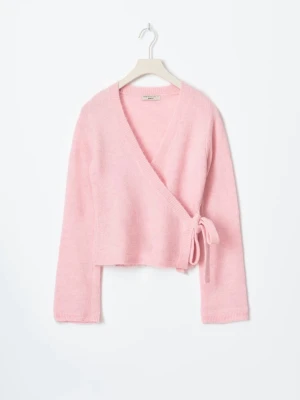 Rosa omlottkofta från ginatricot - Slutsåld Söt ljusrosa stickad omlottkofta från Ginatricot med knytband i sidan och v-ringad hals. Koftan har långa ärmar och är tillverkad i ett mjukt, fluffigt material som känns riktigt mysigt. Perfekt för lager-på-lager och en trendig look.