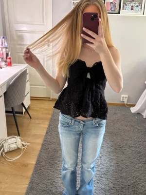 Söt tubtopp i svart  - Supersöt svart tybtopp med broderade detaljer och knyt framtill. Toppen är ärmlös och har en lätt utsvängd passform som ger en luftig känsla. Säljer då den inte kommer till användning 💗💗💗