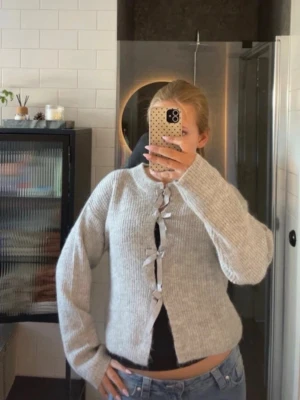 Grå stickad kofta från Gina Tricot -  grå stickad kofta från Gina Tricot med rosetter 