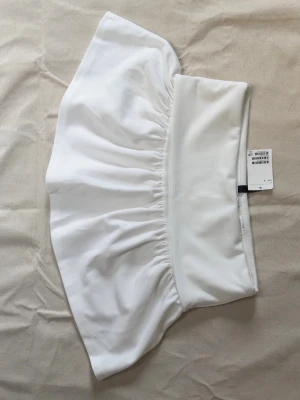 Vit kortkjol från Zara i polyester - Superfräsch vit kortkjol från Zara med bred midja och lätt rynkad design. Kjolen är gjord i mjuk polyester.