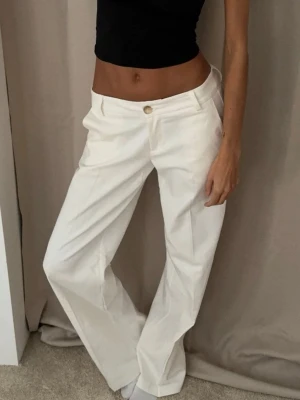 Vita vida kostymbyxor - Säljer ett par vita kostymbyxor med låg midja och vida ben. Dessa fantastiska byxorna har tyvärr blivit för korta på mig (är 172) men de är sååå fina och våriga ❤️nypris 650