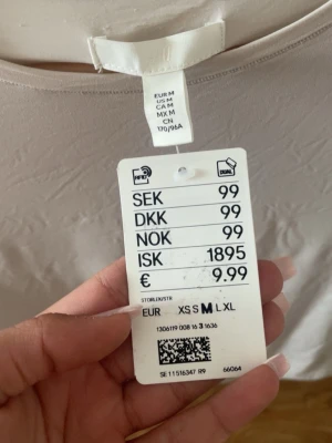 Beige kortärmad body från H&M - Säljer en beige topp i body från Hm. HELT NY!!!!! Jag köpte en och fick en så nu säljer jag en av dem.