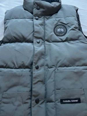 Canada Goose väst  - Grå canada goose, storlek S , pris kan diskuteras. Har också en Qr kod som man kan skanna. MÖTE PLATS 