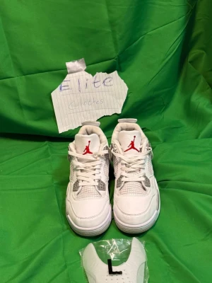 Vita Air Jordan 4 oreo - Nike Air Jordan 4 White Cement sneakers i vitt skinn med grå och svarta detaljer. Klassisk siluett med meshpaneler, snörning och specklad grå sula. Röd Jumpman-logga på plösen och grå Jumpman på hälen. Perfekta för dig som vill sticka ut med en ikonisk sneaker.Liknande modell som originalet!