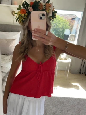 Röd topp med volang - Jättefin topp från Nelly, endast använd 1 gång! Storlek XXS men stretchig!