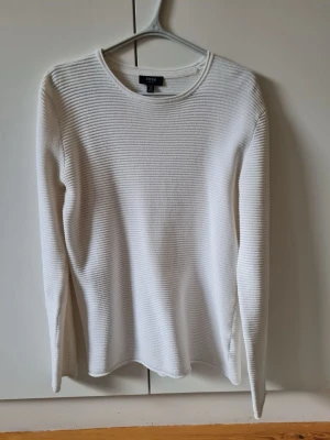 Vit ribbad tröja från SMOG (New Yorker) strl M - Vit långärmad tröja från SMOG (New Yorker) i slim fit-modell. Tröjan har ett ribbat, horisontellt mönster. Material bomull och polyester.  Storlek M.