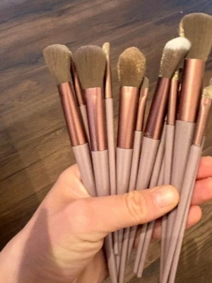 Set med sminkborstar i rosa och koppar - Ett set med flera sminkborstar i olika former och storlekar. Borstarna har ljusrosa handtag och kopparfärgade detaljer vid borsthuvudet. Perfekta för ögonskugga, contour och highlight. Borsthuvudena är mjuka och täta. 13 delar