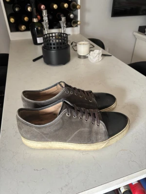 Gråa Lanvins - Ett par gråa lanvins i storlek 45, dem är i bra skick och flytigt använda och har ägt dom i strax 1 år, inga synliga defekter eller hål förutom att mockan skulle behöva borstas upp lite, Hör av er vid intresse