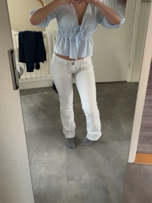 Vita bootcut jeans med fickdetaljer - Säljer ett par vita bootcut jeans med snygga fickdetaljer bak och klassisk femficksmodell. Jeansen har normal midja och är tillverkade i ett stretchigt material som sitter bekvämt! 💕