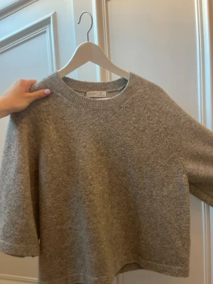 Grå stickad tröja från & Other Stories - Jätte fin och mysig grå stickad tröja med korta ärmar. Perfekt till sommaren när man vill ha något stickad som inte ör för varm pga de korta ärmarna men som ändå är hyfsat varm på kvällarna när de KNA bli lite extra kyligt.