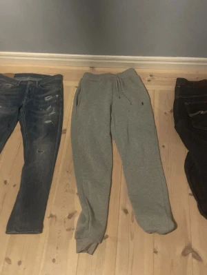 Gråa mjukisbyxor med dragsko - Säljer ett par klassiska gråa mjukisbyxor med dragsko i midjan och resår vid bensluten. Byxorna har sidofickor och är perfekta för chill dagar. Materialet ser ut att vara mjukt och bekvämt, troligen bomullsblandning.