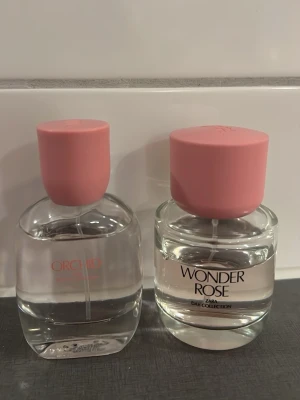 Zara Wonder Rose & Orchid parfym - Två parfymer från Zara: Wonder Rose och Orchid. Båda flaskorna är genomskinliga med rundad form och har stilrena rosa korkar. Perfekta för dig som gillar fräscha och blommiga dofter. Snygg design som passar på sminkbordet.