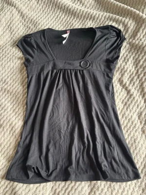 Svart topp med knappdetalj - Jättesnygg topp, storlek L, men passar även S-M beroende på hur man vill dens ska sitta. Har tyvärr ingen bild med den på och kommer inte gå ned i pris💗💗