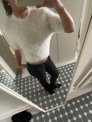 Vit fluffig croppad topp - Säljer en supermjuk och fluffig vit tröja med korta ärmar och rund hals. Nypris 500kr