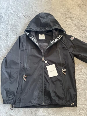 Moncler vindjacka  - Säker en svart Moncler vindjacka perfekt till våren. Scanner funkar ej! Qr kod fungerar. Priset är inte hugget i sten vid snabb affär.
