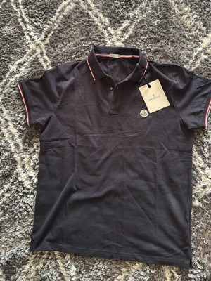 Mörkblå  pikétröja från Moncler - Helt ny storlek XL men passar M och L för att moncler går upp i storlek.