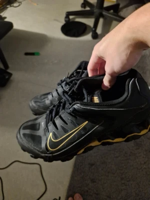 Nike svarta sneakers med gul swoosh - Nike sneakers i svart med gul swoosh och detaljer. Skorna har en sportig design med mesh och syntetmaterial, samt en robust sula med gul accent. Lågt skaft och snörning framtill. Perfekta för dig som gillar streetwear och sportig stil. Lite gamla .