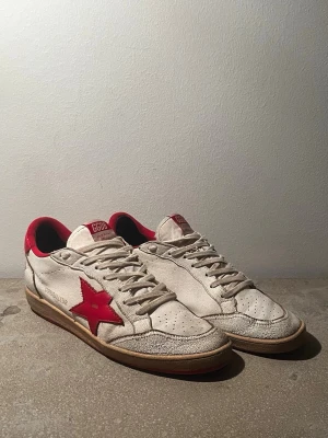 Golden Goose Ballstars - Tänkte göra en intressekoll på dessa Golden Goose Ballstars, Storlek 43 men fungerar för er som har mellan 42-43.5, dom är okej skick i övrigt förutom slitningar under på sulan dock Inget som märks av under användning, spruckit i lädren och i det röda tyget vid hälen men inget som heller märks av! Box medföljs samt dustbags! Riktigt sköna skor i övrigt, för er som kanske är intresserade så är det bara att höra av sig! Pris är inte bestämt men kom med förslag!