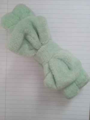 Mintgrönt fluffigt hårband med rosett - Supersött mintgrönt hårband från Makeup Mekka i mjukt, fluffigt material. Hårbandet har en stor rosett framtill och är perfekt för att hålla håret borta vid sminkning eller hudvård. Elastiskt och bekvämt att bära. Hårbandet har använts vid ett fåtal gånger men har inga spår av användning.
