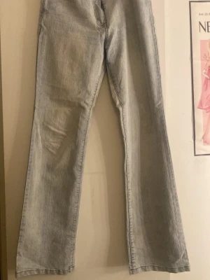 Ljusblå bootcut jeans - Säljer ett par ljusblå bootcut jeans med klassisk femficksdesign. Jeansen har en avslappnad passform och är tillverkade i denim med lätt tvättad look. Perfekta för en trendig och avslappnad stil.