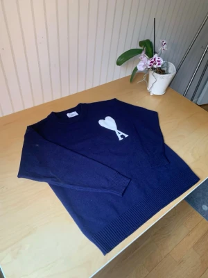 Mörkblå stickad tröja Ami Paris - Mörkblå stickad tröja från Ami Paris med vitt hjärta och bokstaven 'A' på bröstet