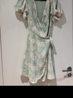 Adoore klänning  - Superfin blommig klänning från Adoore. Väldigt fint skick då jag endast använt den en gång!  Man kan dra åt banden mer eller mindre för att reglera urringningen. Puffig ärm. Dubbelt tyg. ”Fint tyg”. Slutar lite över knäna på mig som är 164.  Stl 36. Men skulle säga att den passar 34-38 då man knyter själv. Köpt för 1500kr. Kom gärna med bud! Kan fixa bild med den på!