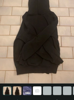 Svart hoodie med luva - En klassisk svart hoodie med luva och magficka. Hoodien har ribbade muddar vid ärmslut och nederkant. Perfekt för en avslappnad och enkel stil. Passar till det mesta och är superbekväm.