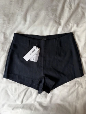 Kostymshorts - Marinblå kostymbyxor med ränder från Gina Tricot som är helt nya 💕💕 har dragkedja på sidan och nypris är 120kr 