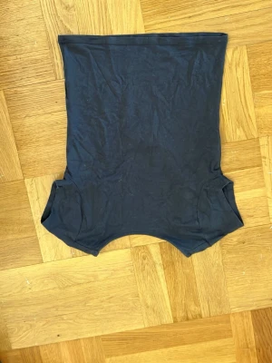 Svart croppad topp med öppen rygg  - Snygg svart croppad topp med korta ärmar och öppen rygg. Tillverkad i mjuk bomull som känns skön mot huden.