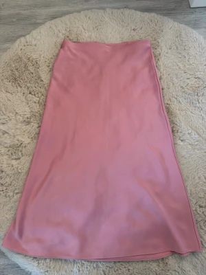 Rosa satinlångkjol från Zara - Säljer en lång rosa satinkjol från Zara. Använd fåtal gånger men inga tydliga tecken på användning. Storlek M! 💓😍