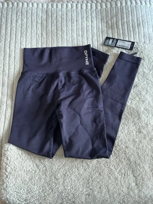 Helt nya DFYNE dynamic leggings - Säljer nu mina helt nya dynamic leggings från DFYNE med prislappen kvar! (Se bild). Slutsåld på hemsidan. Innerbensmåttet är 76cm och modellen på sista bilden är 175cm! De är marinblå och inte svarta!! Nypris 649kr