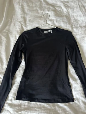 Svart långärmad topp från Weekday - Tajt långärmad tröja i superskönt material. Bara testad aldrig använd.