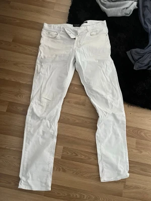 Vita slim fit jeans från Massimo Dutti - Snygga vita jeans från Massimo Dutti i slim fit-modell. Klassisk femficksdesign och raka ben. Perfekta för dig som vill ha en clean och fräsch look. Tillverkade i ett mjukt och bekvämt material som passar året runt.