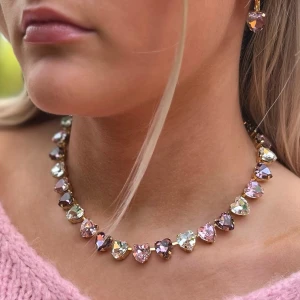 Halsband hjärtan kristaller  - Halsband hjärtan, med blandade kristaller Aurora, Preciosa, Swarowski, egen design. Guldpläterad mässing.  Light Rose, Light Amethyst och Clear Crystal hjärtformade kristaller 11x10mm. Längd 46cm inkl lås och förlängningskedja. Tillhörande armband, ring och örhängen finns.  Jag skickar endast spårbart, samfraktar. Fast pris. Besök gärna mina övriga annonser.  Till mina smycken använder jag kristaller från Preciosa, Aurora och Swarowski.