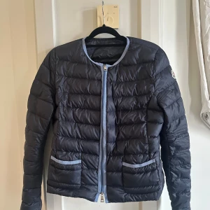 Mörkblå moncler dunjacka - Så snygg mörkblå tunn jacka från moncler med ljusblå detaljer. Fråga gärna om fler bilder då plick endast tillåter fem st. Köpt på Vestiaire collective, fortfarande bra skick! Storlek 2 vilket egentligen motsvarar xxxs men passar mig som brukar ha S.