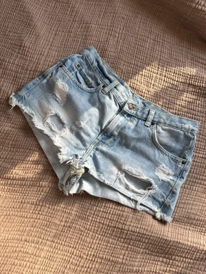 Jeansshorts  - Mått finns på bilderna. Osäker på storleken då det inte står men tror att det är 36.
