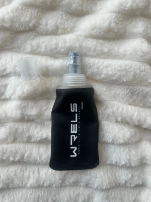 Vattenflaska till löpning  - Säljer en helt ny vattenflaska som fungerar till löpning och passar i en löparväst eller löparbälte. Plombering kvar. Rymmer 150ml. 